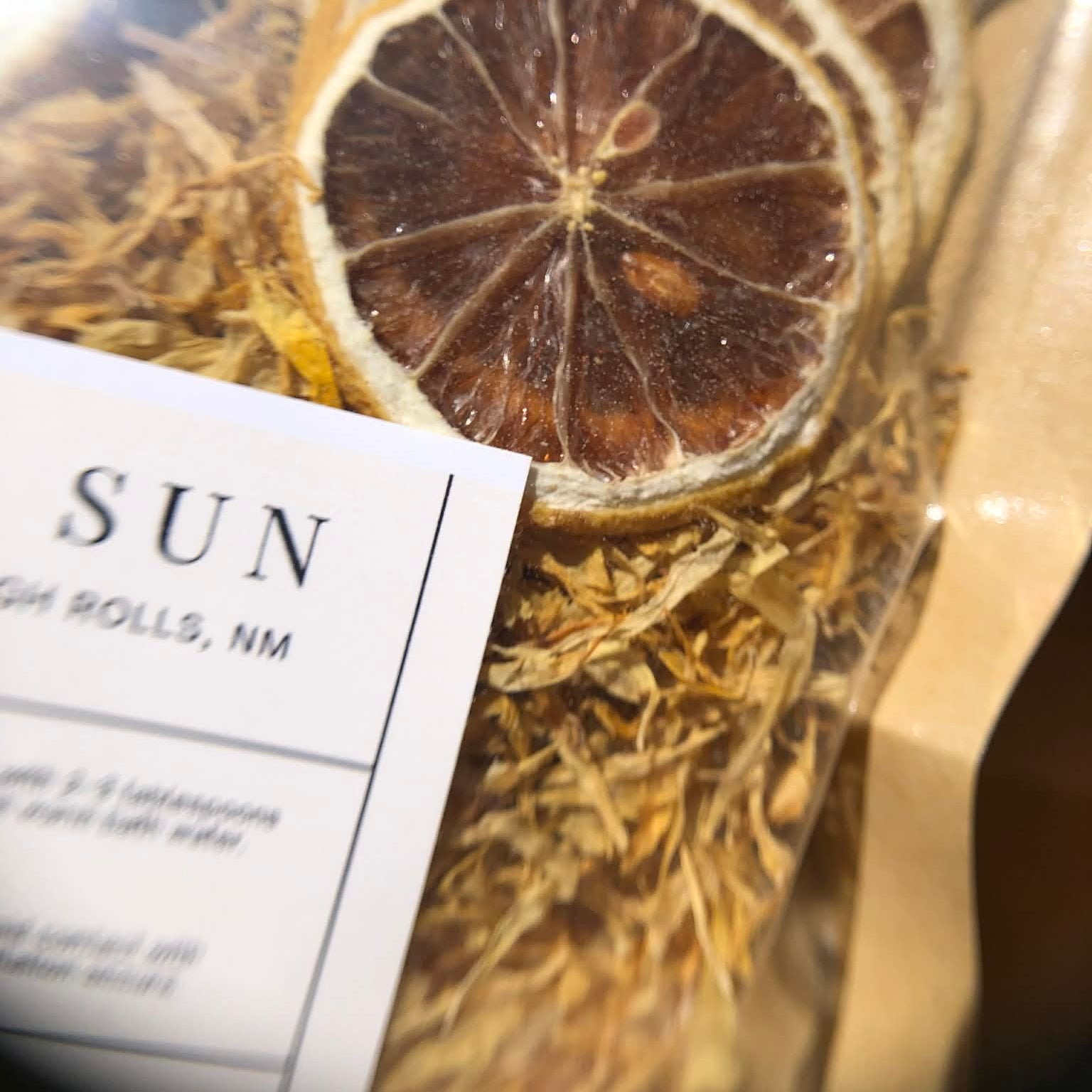 Dried lemon slices and herbs with a label on a dark background