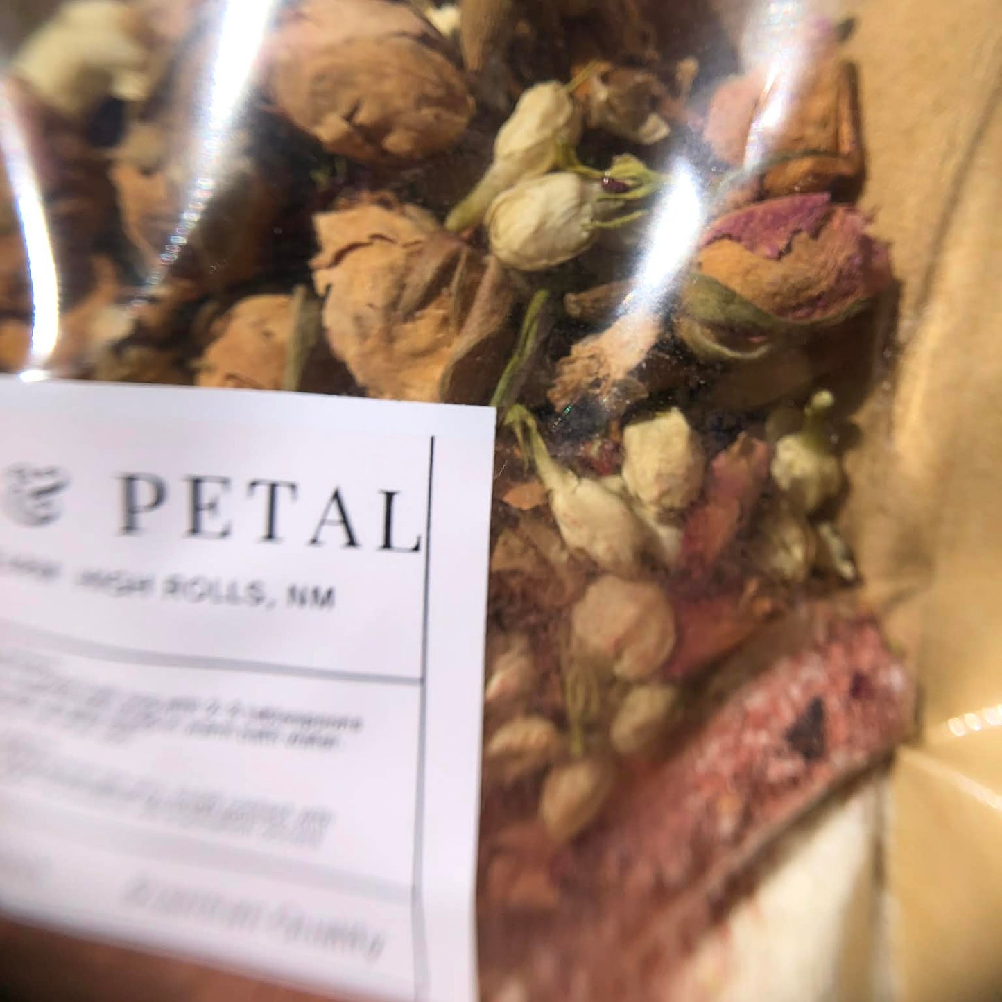 Bag of dried flowers, herbs, and bath salts with a 'Stone & Petal' label.